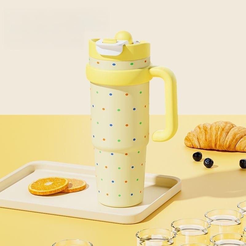 Yellow 1000ml thermos with colorful polka dots and wuth a straw