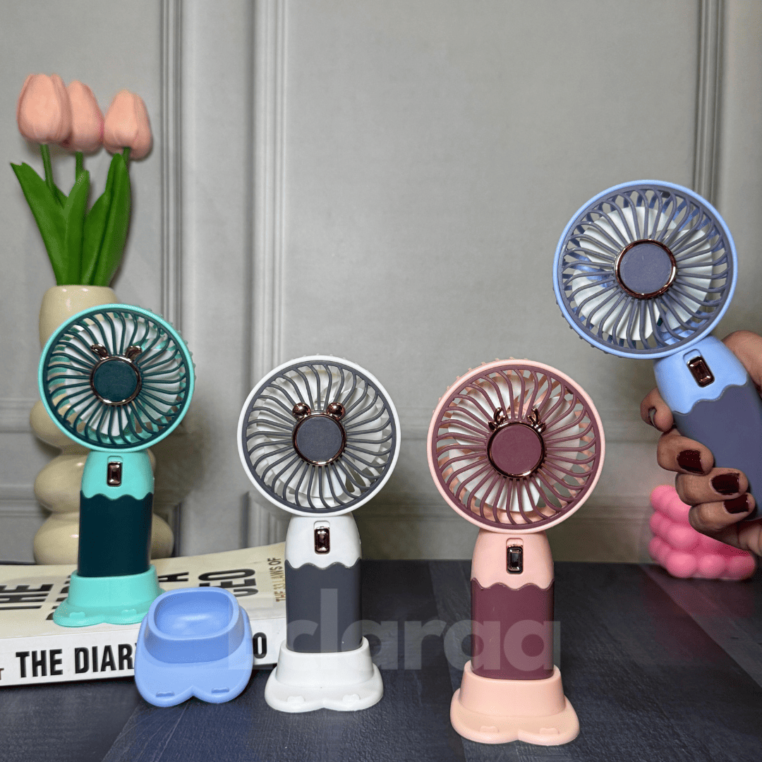 Four small handheld fans in different colors white , pink , mint green and blue